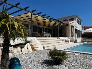 a house with a swimming pool and a pergola at Villa Tina Maria with seaview near Porec in Markovac