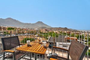 eine Terrasse mit einem Tisch und Stühlen auf dem Balkon in der Unterkunft Suite Mirador del Galeón in Adeje