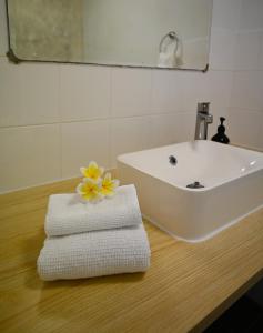 un bagno con lavandino e asciugamani su un tavolo di Rumah Biru a Flying Fish Cove