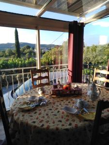 a dining room with a table and a large window at LA GRAND'VIGNE in Chauzon