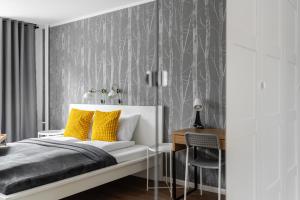 a bedroom with a bed with yellow pillows and a desk at Green View Apartment with Balcony Winogrady by Noclegi Renters in Poznań