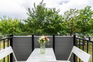 a vase of flowers on a table on a balcony at Green View Apartment with Balcony Winogrady by Noclegi Renters in Poznań