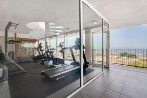 an indoor gym with treadmills and elliptical machines at Suite Mirador del Galeón in Adeje