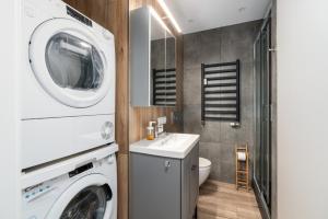 a bathroom with a washing machine and a sink at Green View Apartment with Balcony Winogrady by Noclegi Renters in Poznań +14 photos