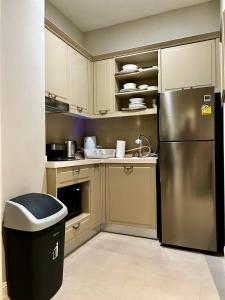 a kitchen with a stainless steel refrigerator and a trash can at Blue Sky Khao Kho Castell Condo in Campson