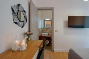 a room with a table with candles and a bedroom at Bissenti Rooms - Eja Sardinia in Cagliari