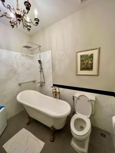 a bathroom with a tub and a toilet and a chandelier at Blue Sky Khao Kho Castell Condo in Campson