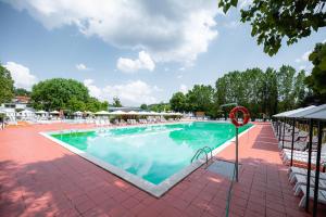 a large swimming pool with chairs and umbrellas at Glamping Tuscany in Capannole