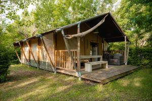 a small house with a porch and a porch swing at Glamping Tuscany in Capannole