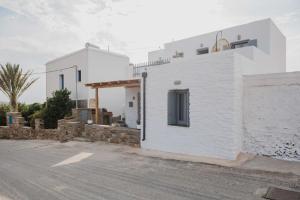 a white building on the side of a street at Falakis Apartments in Kithnos