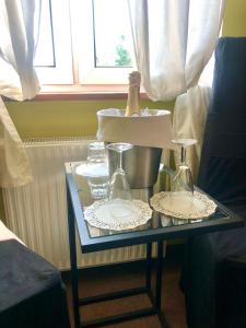a glass table with a bottle and glasses on it at Folwark Nadmorska Ostoja in Mechelinki