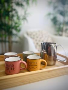 quatro canecas de café sentadas numa bandeja de madeira em Vilamoura 2 Bedroom with Pool - Na Casa De Pascal em Vilamoura