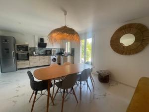 a kitchen and dining room with a wooden table and chairs at Le Val d'escure in Saint-Raphaël