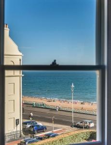 a view of a beach and the ocean from a window at Square Townhouse in Brighton & Hove