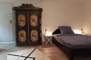 a bedroom with a bed and a large wooden cabinet at FairSchlafen in Bücken