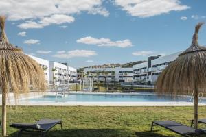 une image de la piscine d'un complexe avec 2 chaises dans l'établissement Residencial Celere Playa Niza, à Almayate