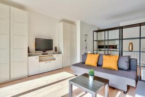 a living room with a couch and a tv at Studio - Appartement Quartier Montparnasse 2 in Paris