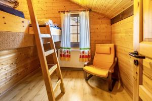 una habitación con una escalera y una silla en una cabaña en Sommerberg en Unterkirnach