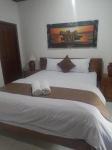 a bedroom with a large bed with two towels on it at Serongga guest house in Lebih