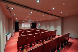 una sala conferenze vuota con sedie rosse e schermo di Hallmark Hotel & SPA Istanbul a Istanbul