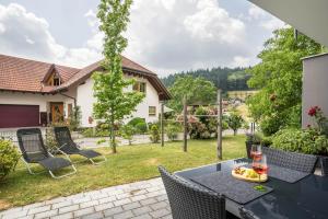 a patio with a table with a glass of wine at Ferienwohnung Hohfelsenblick in Seebach