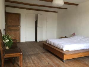 a bedroom with a bed and a wooden floor at Maison du Bûcheron in Melay