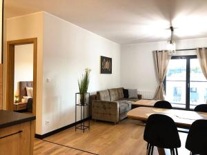 Apartimento Angel River 7 في فروتسواف: غرفة معيشة مع أريكة وطاولة