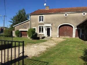 una casa vieja con una puerta marrón y una valla en Maison du Bûcheron, en Melay