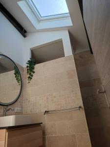 ein Bad mit einer Dusche, einem Fenster und einem Spiegel in der Unterkunft BOHO location 2 in Bonnieux