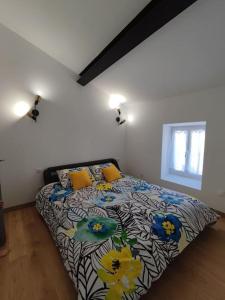 1 Schlafzimmer mit einem Bett mit Blumenbettdecke in der Unterkunft BOHO location 2 in Bonnieux