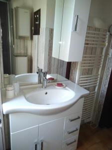 La salle de bains est pourvue d'un lavabo blanc et d'une baignoire. dans l'établissement LA GRAND'VIGNE, à Chauzon