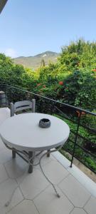 - Balcón con mesa blanca y 2 sillas en Filoxenia Apartments en Mitilene