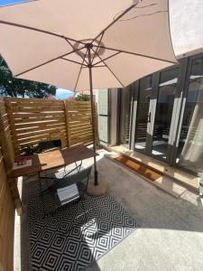 a table with an umbrella on a patio at La Casita Luz in Cavaillon
