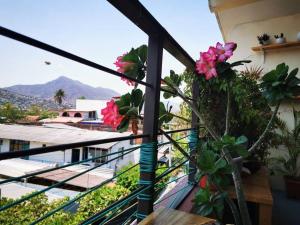 a balcony with flowers and plants on a building at Panoramic Paradise 5 min to downtown and beach in Zihuatanejo