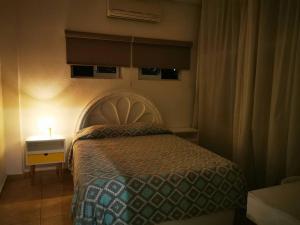 a bedroom with a bed and a lamp on a table at Panoramic Paradise 5 min to downtown and beach in Zihuatanejo