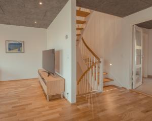 a living room with a tv and a staircase at Breathtaking Views - New - 220m2 - 5 BR - Walks in Tórshavn