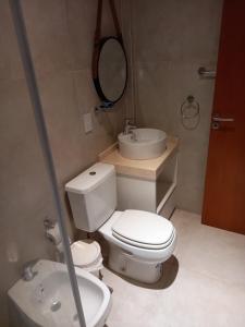 uma casa de banho com um WC, um lavatório e um espelho. em Departamento en Corrientes em Corrientes