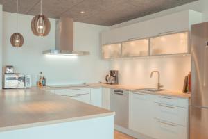 a kitchen with white cabinets and stainless steel appliances at Breathtaking Views - New - 220m2 - 5 BR - Walks in Tórshavn