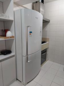 um grande frigorífico branco numa cozinha em Mobiliado e aconchegante em Belém