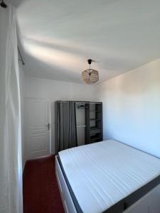a small bedroom with a bed and a chandelier at Charmant séjour Marseillais in Marseille