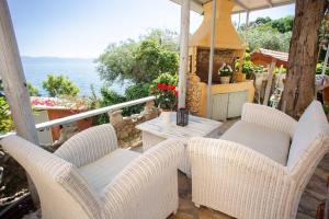 a patio with chairs and a table on a balcony at Kohyli House in Agia Pelagia Chlomou