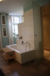 a large bath tub in a bathroom with a window at Flett - Artlands Home - Landhaus für Familien und Gruppen in Badbergen