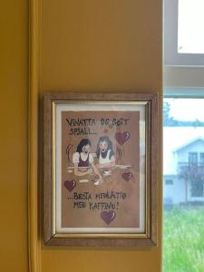 a framed picture of two girls on a wall at Charming 3 bedroom apartment in Akureyri