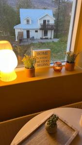 a window sill with potted plants and a house at Charming 3 bedroom apartment in Akureyri