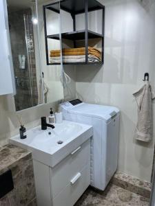 uma casa de banho branca com um lavatório e um espelho em Charming 3 bedroom apartment em Akureyri