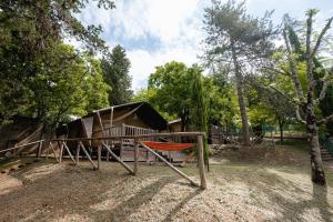 un parque infantil con un tobogán frente a una casa en Glamping Siena en Siena