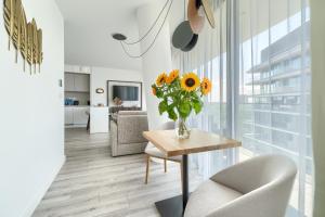 a living room with a vase of sunflowers on a table at Your Holidays Waves B862 in Międzyzdroje