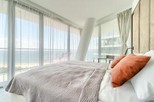 a bedroom with a bed with a view of the ocean at Your Holidays Waves B862 in Międzyzdroje