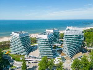 two tall buildings next to a beach with the ocean at Your Holidays Waves B862 in Międzyzdroje