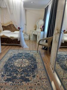 a bedroom with a bed and a rug and a mirror at Hotel Дар-Ай in Kostanay